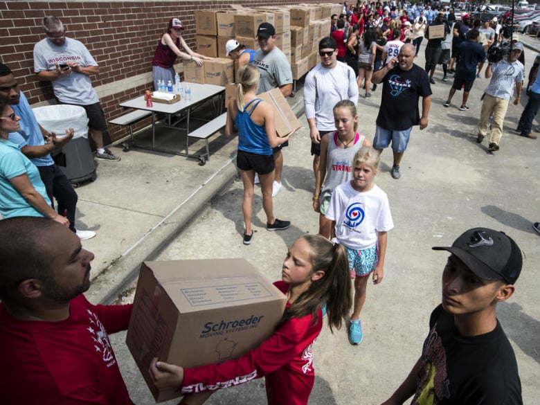 Volunteers unload a truck of relief supplies for people impacted by Hurricane Harvey on Sunday, Sept. 3, 2017, in Houston. 